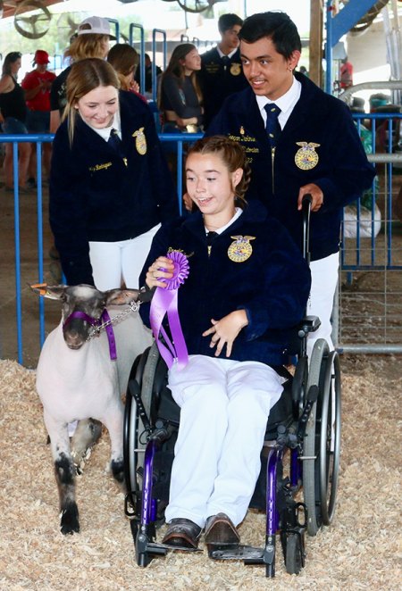 Lemoore High FFA sophomore and her lamb wins first prize at Kings Fair competition Brook Jordan with fellow FFA members and her prize-winning lamb.